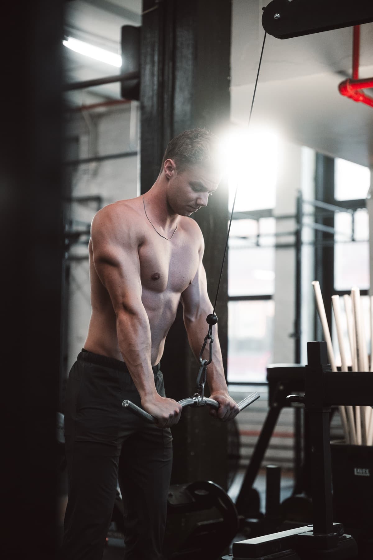 Athlete pulling on a cable stack in the gym.